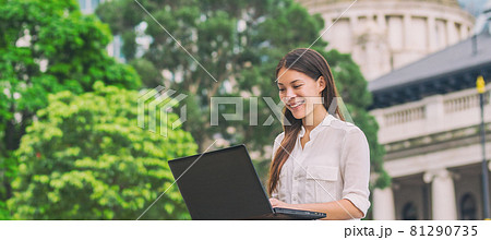 Asian business woman working on laptop computer outside in city park during lunch break, summer work lifestyle. Happy chinese biracial young lady 81290735