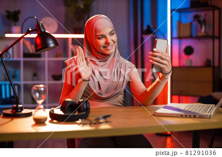 Woman in hijab using cell phone for taking selfie at home 81291036