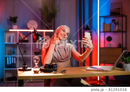 Muslim woman taking selfie on smartphone at home office 81291038