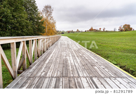 Autumn colorful trees and wooden paved walk landscape. Fall nature background. Great wallpaper design. Autumn colorful trees and wooden paved walk landscape. Fall nature background. Great wallpaper design. 81291789