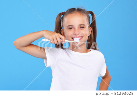 Little lovely girl with two cute ponytails posing with toothbrush and toothpaste on it Little lovely girl with two cute ponytails posing with toothbrush and toothpaste on it 81293028