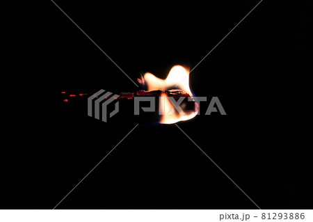 Side view of a burning stick against a black background 81293886