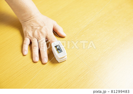 パルスオキシメーターをつけた右手のアップ 81299483
