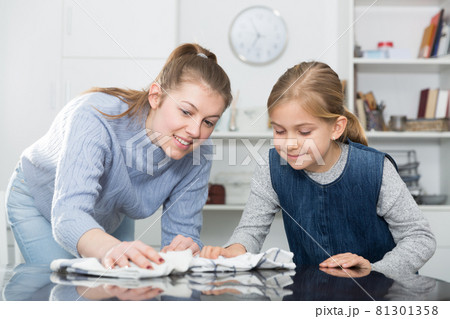 Woman with vacuum cleaner and daughter with rag Woman with vacuum cleaner and daughter with rag 81301358