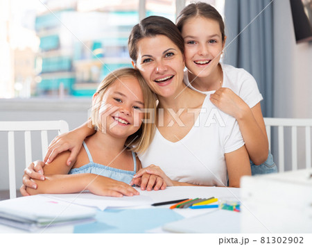 Happy girls with mom draw at the table 81302902