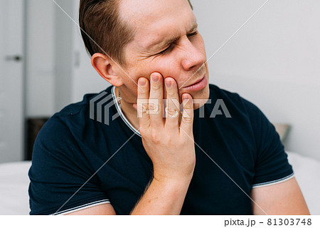 Young Caucasian male grimaces from severe toothache 81303748