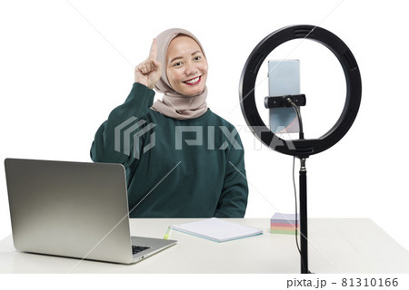 Asian Muslim woman with laptop and mobile phones with lighting equipment make a vlog Asian Muslim woman with laptop and mobile phones with lighting equipment make a vlog 81310166