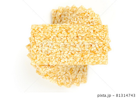 Pile of sesame brittle bars, from above, on white background. Sesame seed candy bars or also crunch, a confection of sesame seeds and honey, pressed into flat bars, a popular snack in the Middle East. 81314743