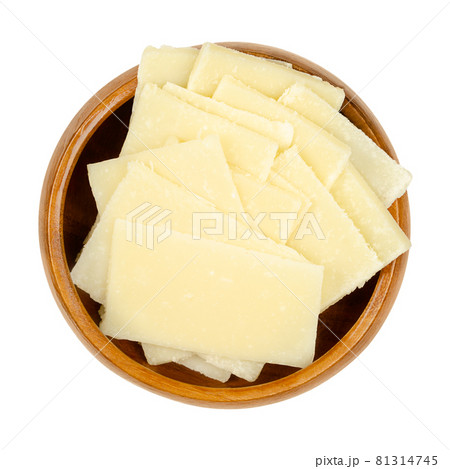 Thin Grana Padano cheese slices, in a wooden bowl. Italian hard cheese, similar to Parmesan, crumbly-textured, with strong savory flavor and slightly gritty texture, made from unpasteurized cow milk. 81314745