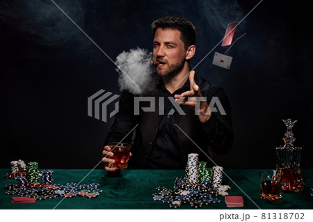 Bearded casino player man playing poker on green table Bearded casino player man playing poker on green table 81318702
