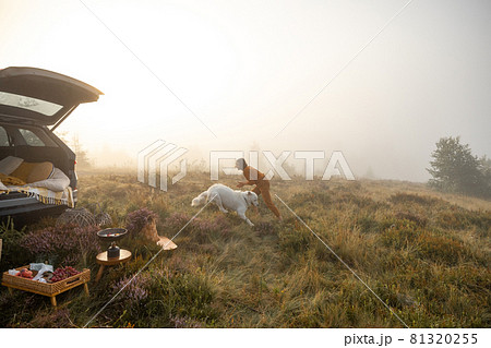 Woman travels with a dog by car in the mountains Woman travels with a dog by car in the mountains 81320255