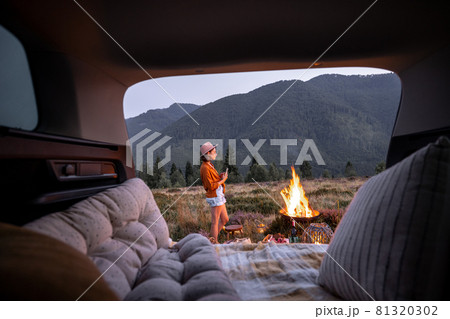 Woman at picnic with bonfire in the mountains Woman at picnic with bonfire in the mountains 81320302