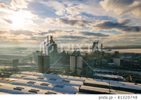 Aerial view of cement plant with high factory structure and tower crane at industrial production area at sunset. Aerial view of cement plant with high factory structure and tower crane at industrial production area at sunset. 81320748