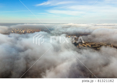 Top aerial view of fluffy white clouds over modern city with high rise buildings. 81321162