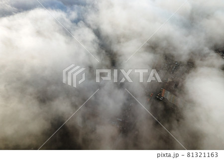 Top aerial view of fluffy white clouds over modern city with high rise buildings. 81321163