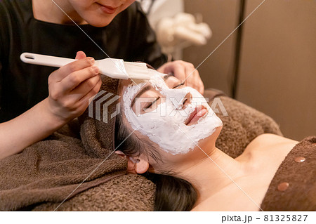 フェイシャルエステサロンで施術を受ける女性 81325827