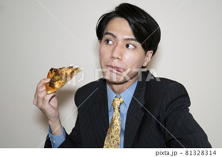 ピザを食べるビジネスマンの男性の写真素材