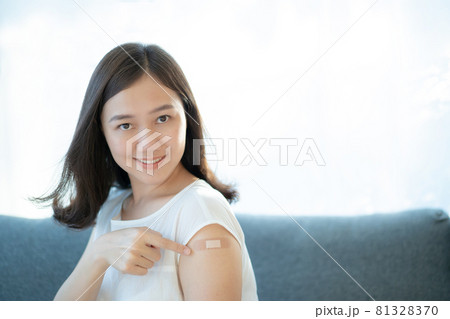 Asian young woman showing a vaccinated point on her arm. Asian young woman showing a vaccinated point on her arm. 81328370