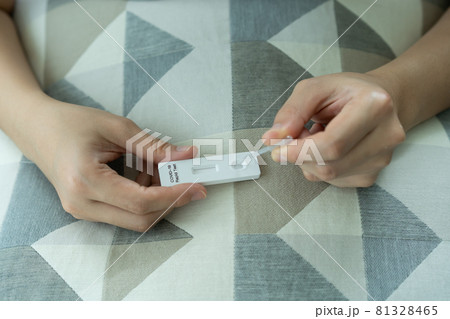Asian young woman teasing a COVID-19 antigen test at home. Asian young woman teasing a COVID-19 antigen test at home. 81328465