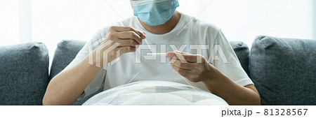 Asian young man testing a COVID-19 antigen test at home. 81328567