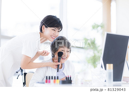 介護　メイクセラピー　メイクをしてもらっているシニア女性 81329043