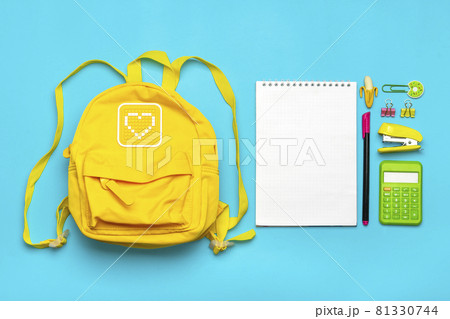 Back to school, education concept. Yellow backpack with school supplies - notebook, pens, ruler, calculator, scissors isolated on blue background Top view Copy space Flat lay composition Banner 81330744