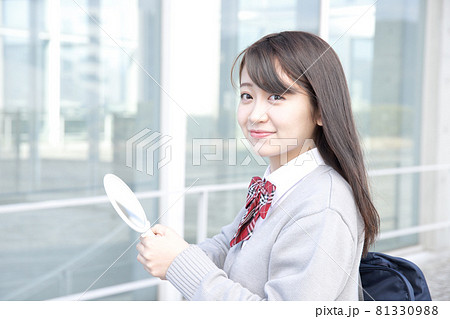 鏡を持って笑顔の女子高校生　ブレザーの制服着用 81330988