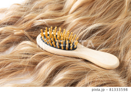 Blond wavy hair and bamboo comb brush Blond wavy hair and bamboo comb brush 81333598