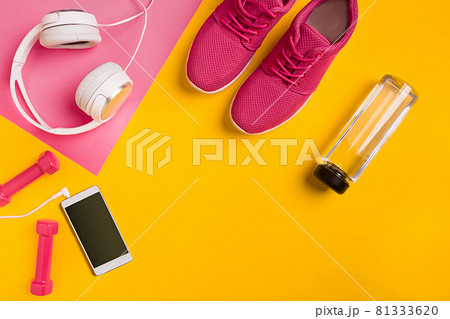 Athlete's set with female clothing, dumbbells and bottle of water on yellow background 81333620