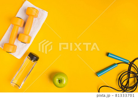 Athlete's set with female clothing, dumbbells and bottle of water on yellow background Athlete's set with female clothing, dumbbells and bottle of water on yellow background 81333701