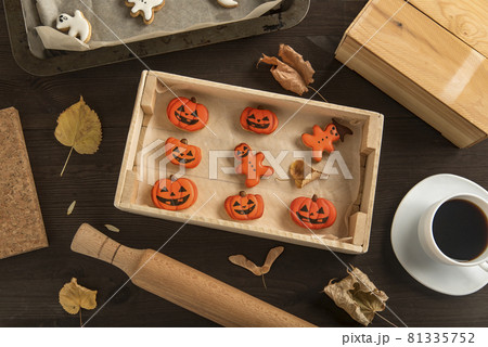 Ginger cookies for Halloween lie in a wooden form on the table. In pumpkin shape. Very tasty to eat with a cup of coffee Ginger cookies for Halloween lie in a wooden form on the table. In pumpkin shape. Very tasty to eat with a cup of coffee 81335752