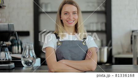 Beautiful female barista is happy smile in coffee shop bar. Portrait of happy employee behind cozy loft-style cafe counter in restaurant. Beautiful female barista is happy smile in coffee shop bar. Portrait of happy employee behind cozy loft-style cafe counter in restaurant. 81336168