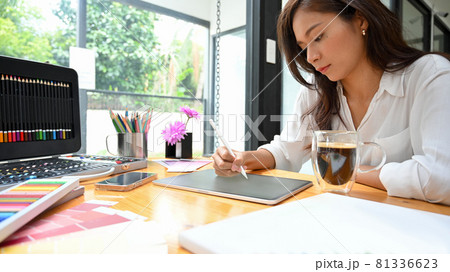 Young female graphic designer using stylus and tablet sketching new art model Young female graphic designer using stylus and tablet sketching new art model 81336623