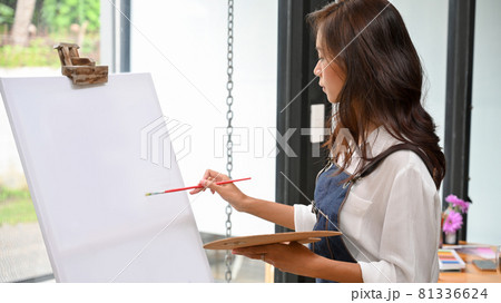 Blank canvas easel mockup for your artwork painting by attractive female artist Blank canvas easel mockup for your artwork painting by attractive female artist 81336624