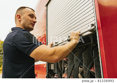 Fireman standing by firefighting truck with special tools 81336993