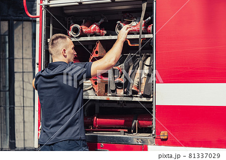 Firefighter standing by truck with special equipment Firefighter standing by truck with special equipment 81337029