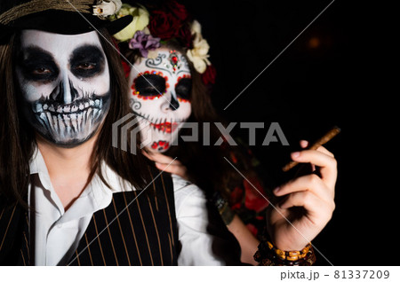 Woman in santa muerte costume and man in skeleton bodypainting for halloween. 81337209