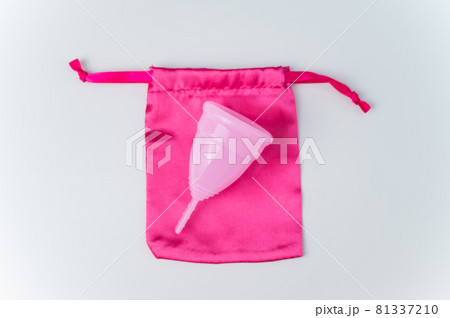 Pink menstrual cup and silk bag on a white background. Copy space Pink menstrual cup and silk bag on a white background. Copy space 81337210
