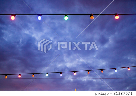 colorful light bulbs against dark blue sky background colorful light bulbs against dark blue sky background 81337671