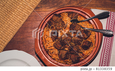Dish of spaghetti and meatballs on a wooden table 81338359
