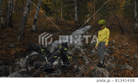 The woman travel on mixed terrain cycle touring with bikepacking. The traveler journey with bicycle bags. Sport tourism bikepacking. The woman travel on mixed terrain cycle touring with bikepacking. The traveler journey with bicycle bags. Sport tourism bikepacking. 81341438