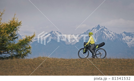 The woman travel on mixed terrain cycle touring with bikepacking. The traveler journey with bicycle bags. Sport tourism bikepacking. The woman travel on mixed terrain cycle touring with bikepacking. The traveler journey with bicycle bags. Sport tourism bikepacking. 81341532