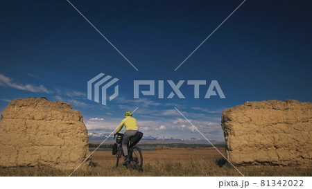 The man travel on mixed terrain cycle touring with bikepacking. The traveler journey with bicycle bags. Sport tourism bikepacking. 81342022