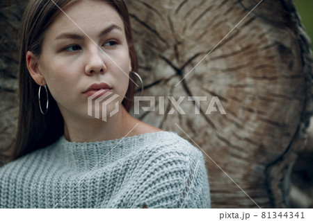 Pretty young woman at sawing tree outdoor in the park at summer. 81344341