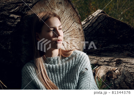 Pretty young woman at sawing tree outdoor in the park at summer. 81344376