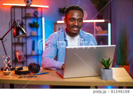 Young man sitting at desk and working on laptop 81346198