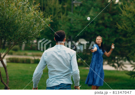 Young adult couple playing badminton in the park Young adult couple playing badminton in the park 81347047