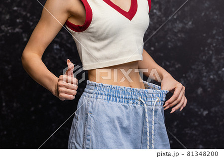 Woman showing how much weight she lost. Woman showing how much weight she lost. 81348200
