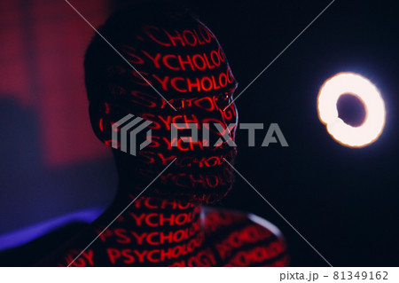 Young adult man with word Psychology on his face in the dark. Young adult man with word Psychology on his face in the dark. 81349162