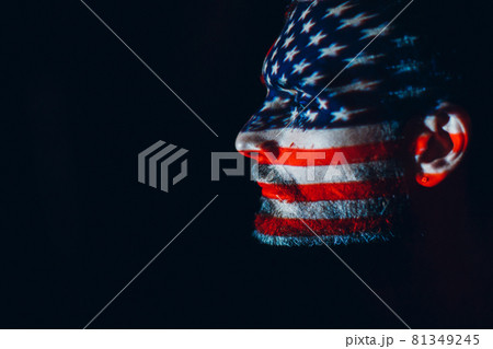 Adult man with USA flag on his face in the dark. Independence Day concept, Adult man with USA flag on his face in the dark. Independence Day concept, 81349245